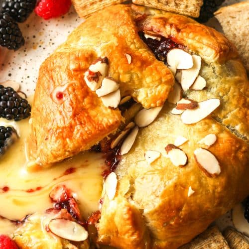 Overhead view of the baked brie and jam in puff pastry on a plate.