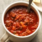 A mug of easy slow cooker chili with a spoon inside.