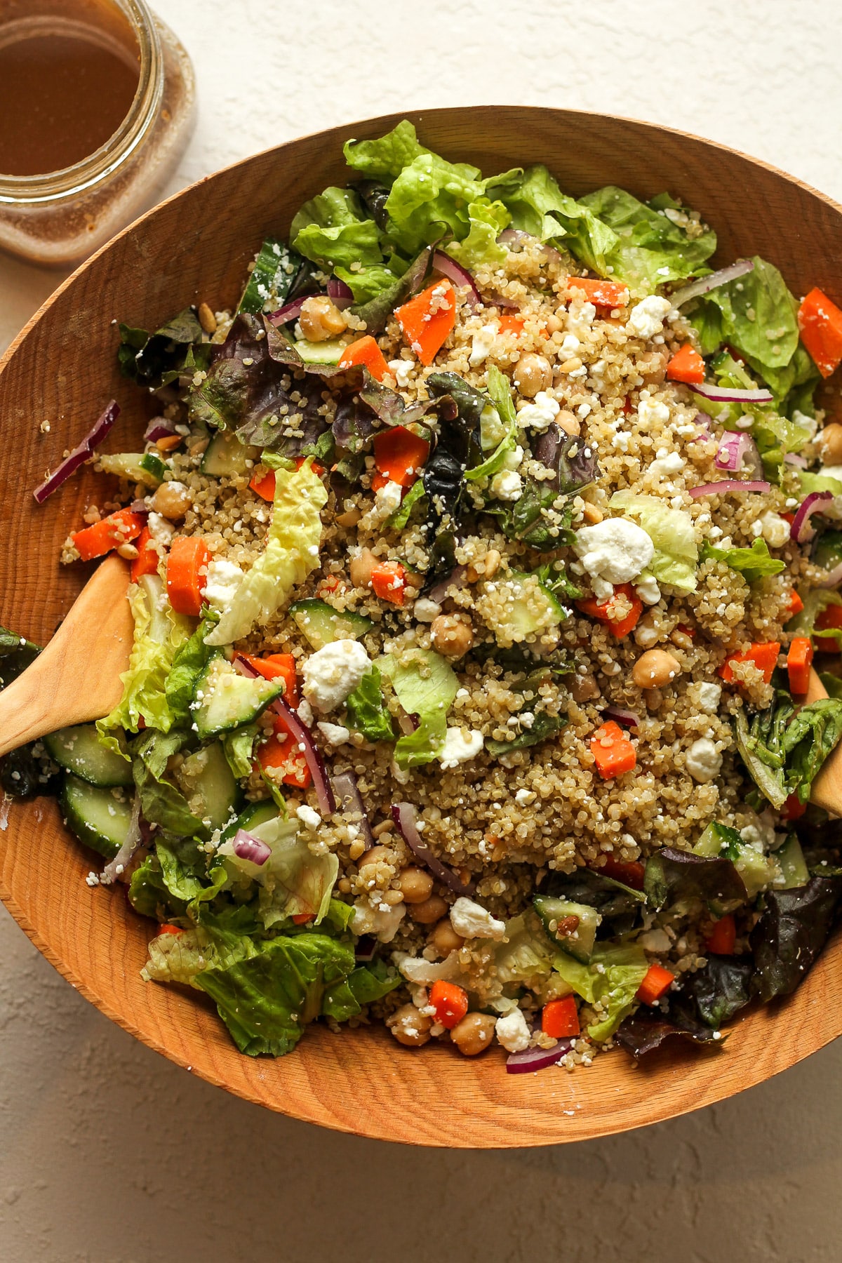 Overhead view of a large bowl of quinoa salad with goat cheese and veggies.