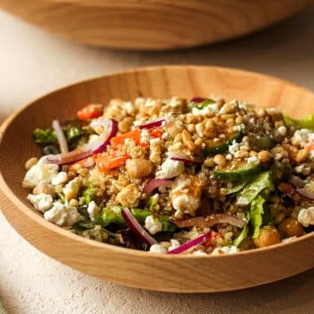 Side view of a serving bowl of goat cheese quinoa salad.