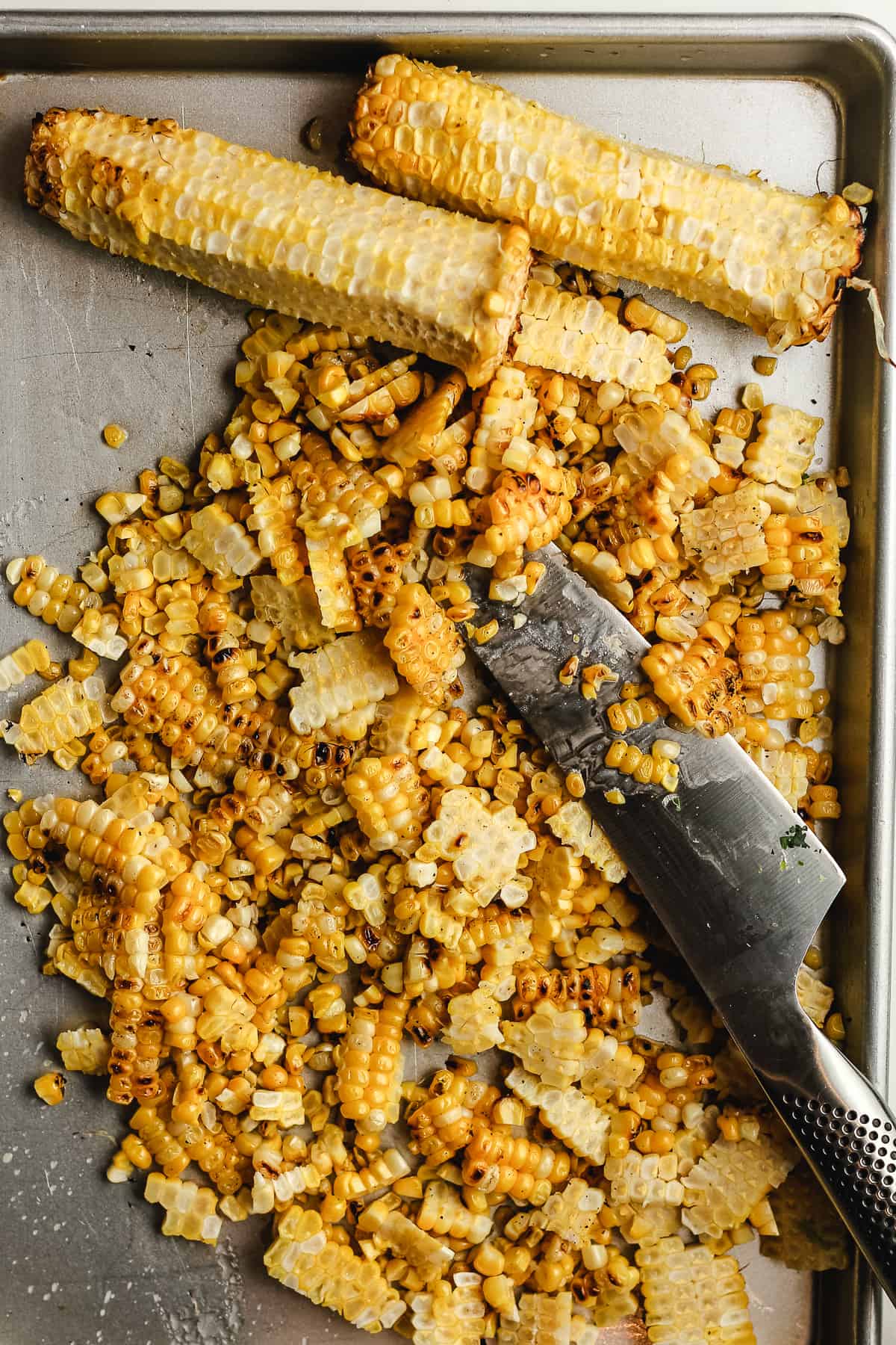 A tray of grilled corn, sliced off the cobs.