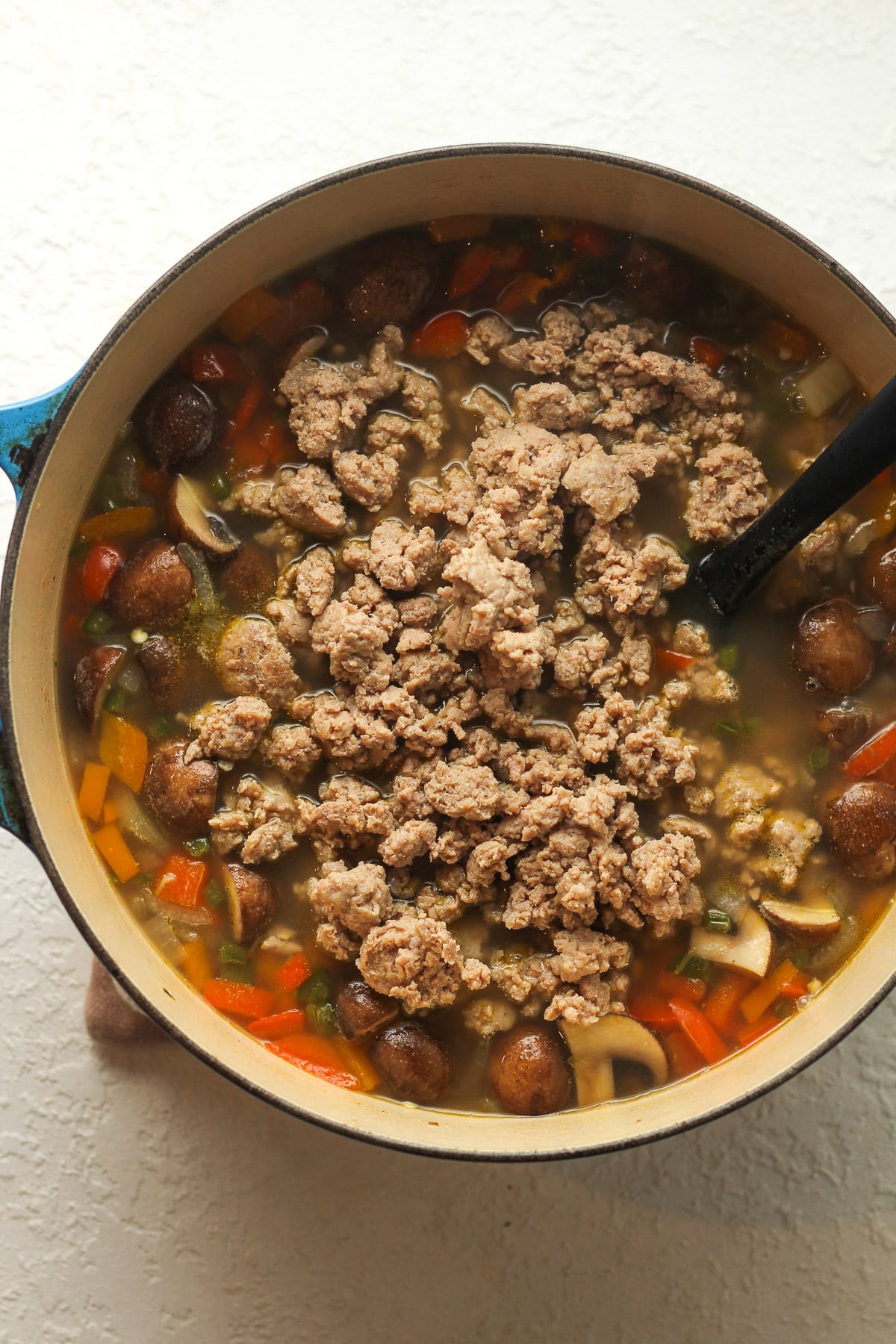 A pot of soup after adding back the sausage.