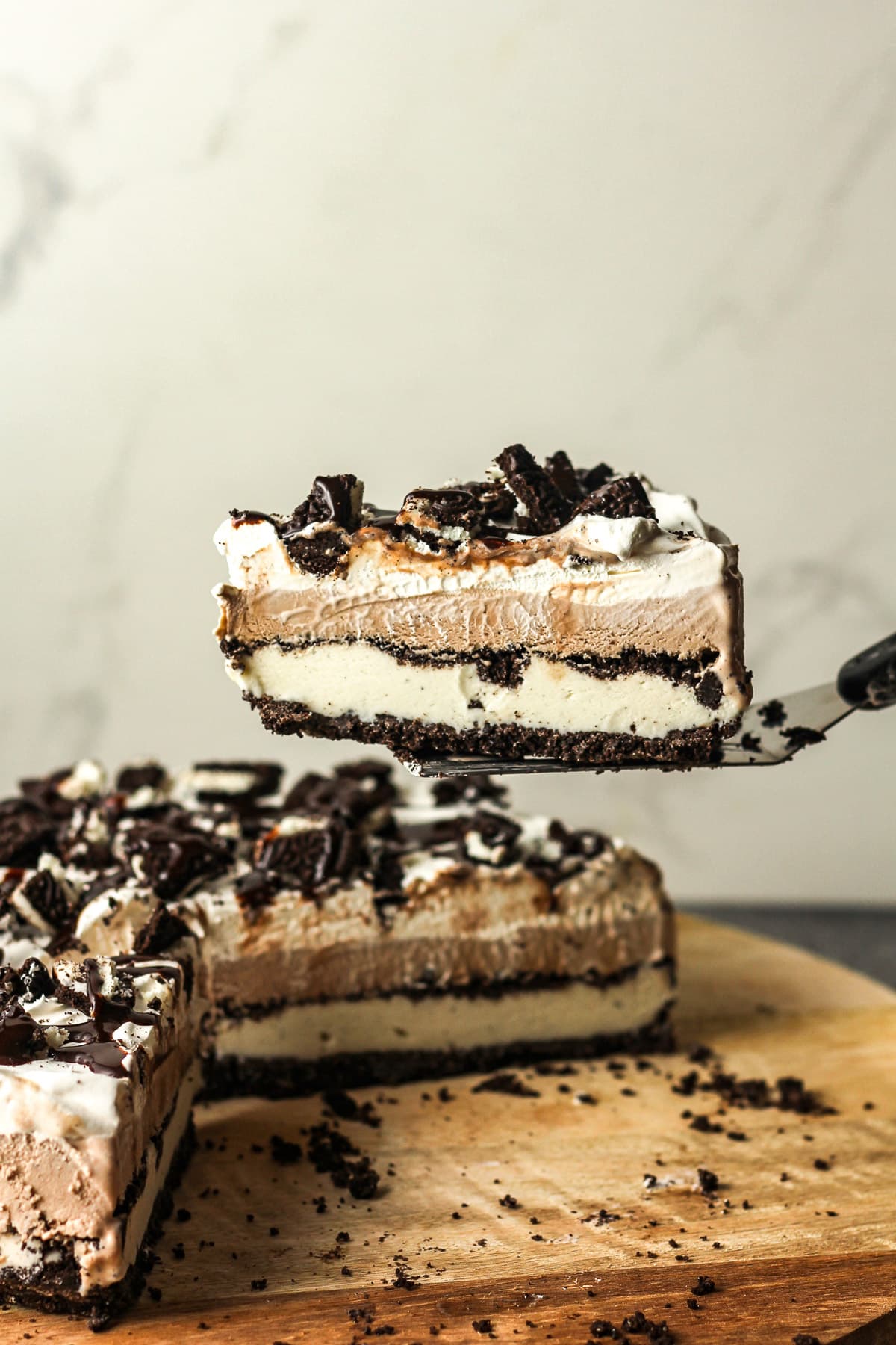 Side view of a spatula lifting a slice of Oreo pie.