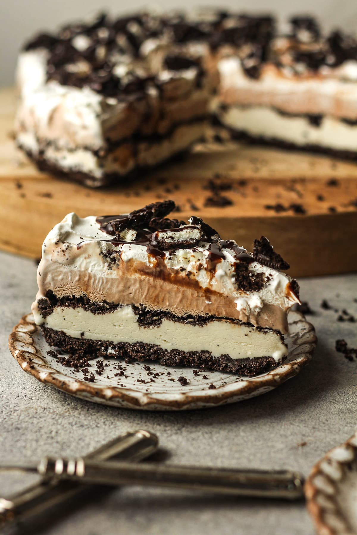 Side view of a slice of Oreo ice cream pie in front of the remaining pie.