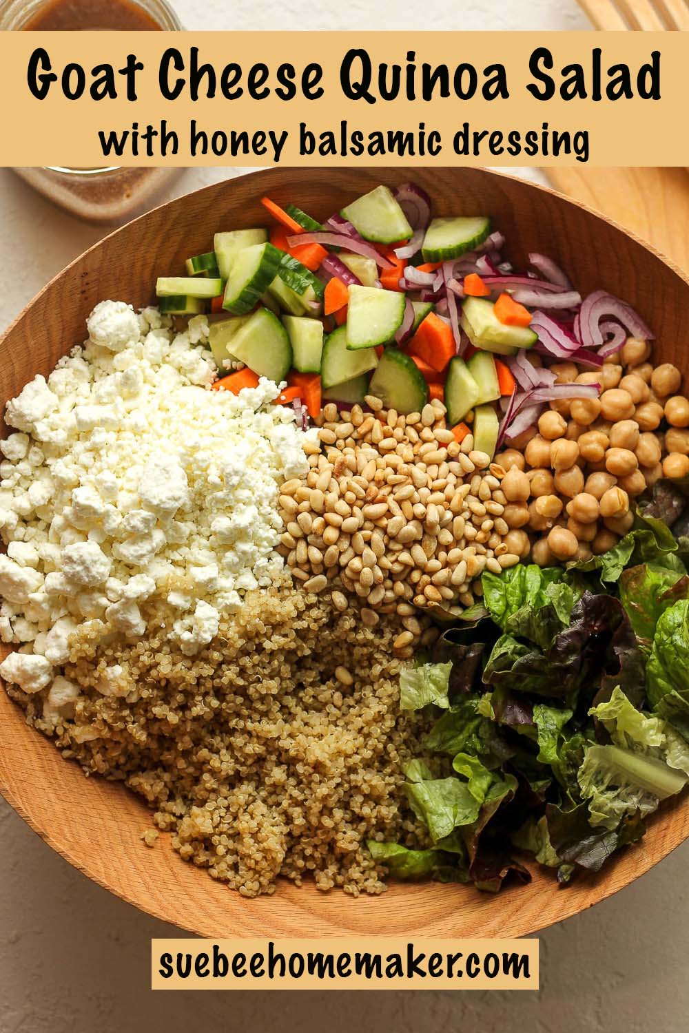 A large bowl of the quinoa salad separated by ingredient with a jar of balsamic dressing.