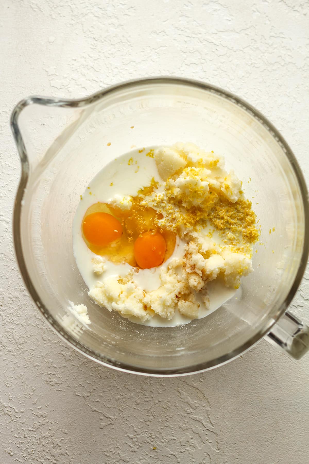 A measuring cup with the wet cake batter ingredients.