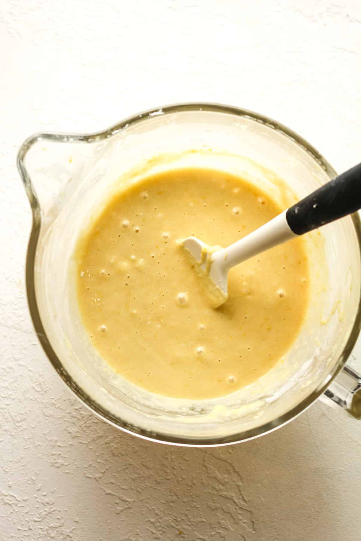 A large measuring cup with the lemon cake batter.