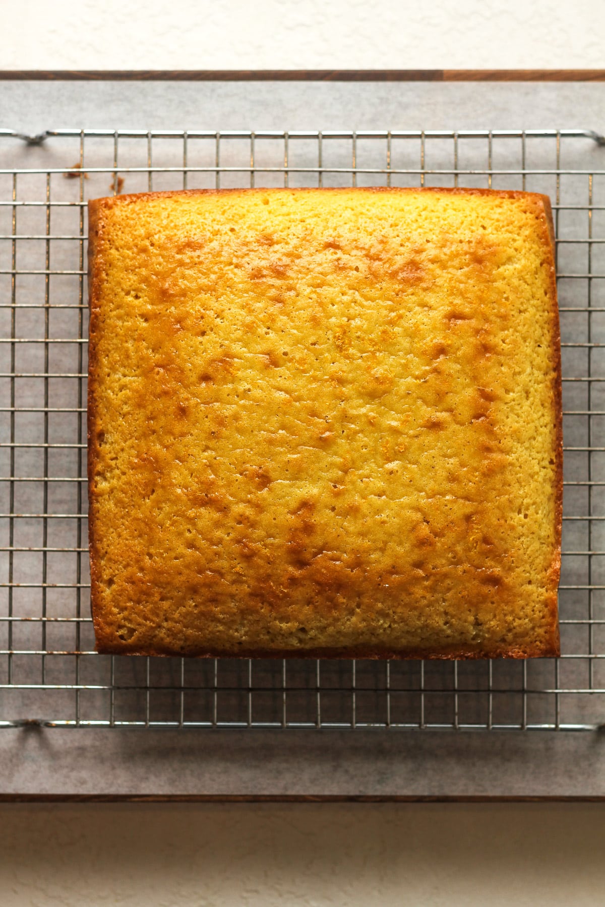 A square lemon cake on a cooling rack.