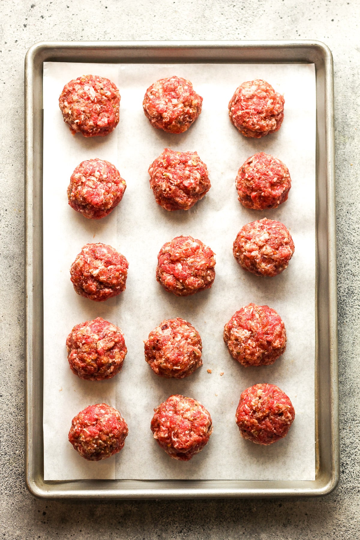 A pan of the stuffed raw meatballs.