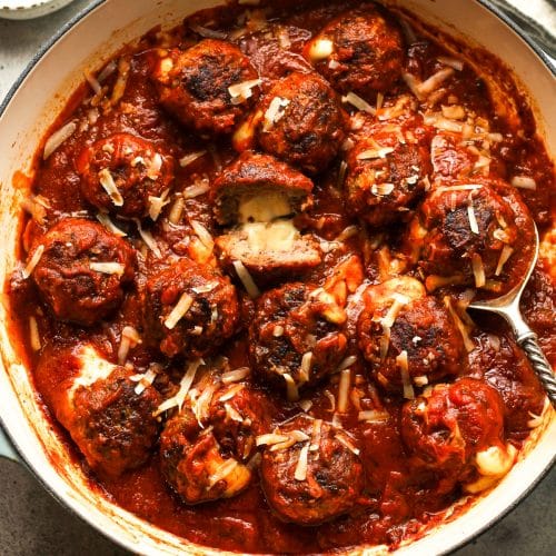 A braiser of simmered stuffed meatballs with sauce.