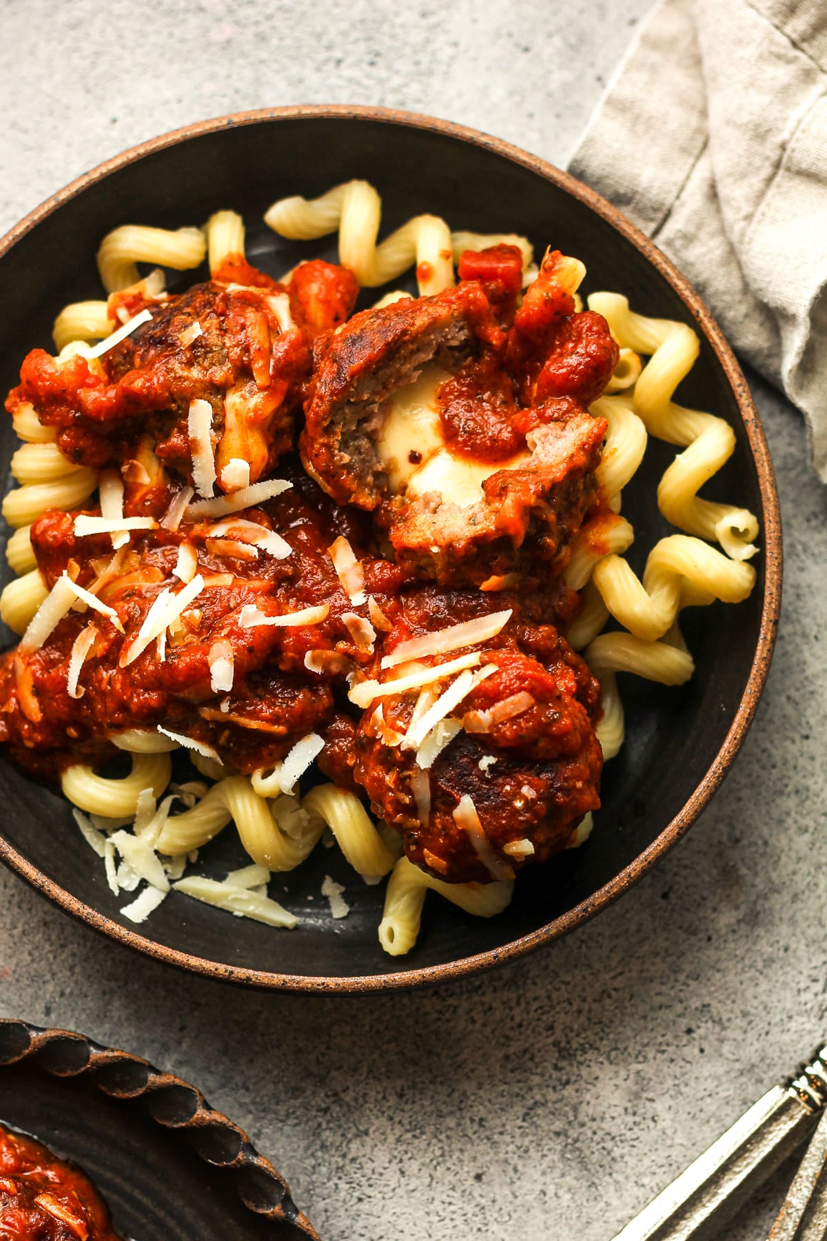 A bowl of the stuffed meatballs over pasta.