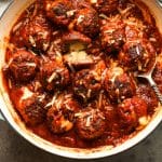 Overhead shot of a pan of mozzarella stuffed meatballs with marinara sauce.