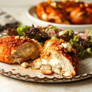 Side view of a stuffed buffalo chicken breast sliced in half.