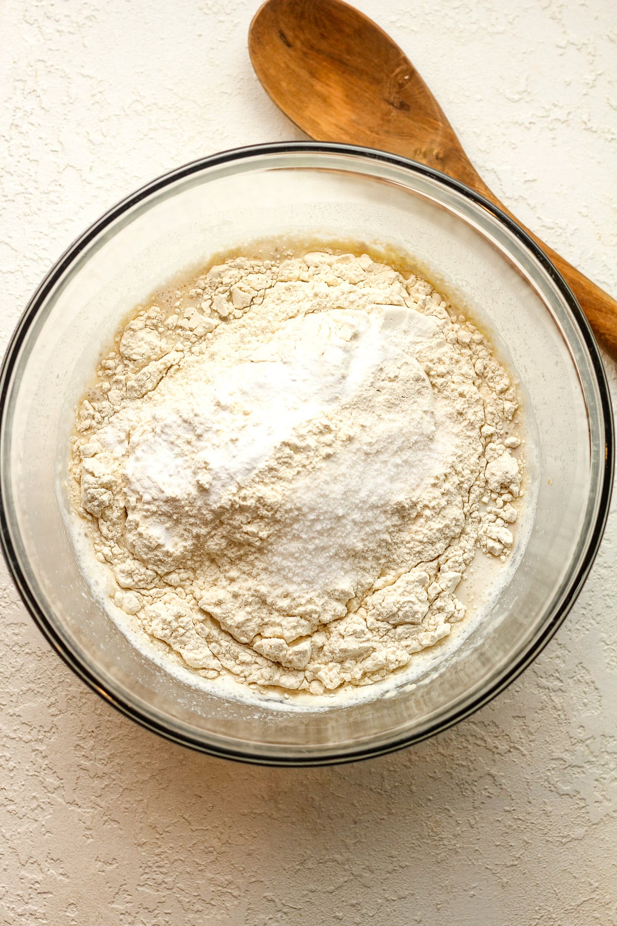 A bowl of the yeast mixture with flour and salt on top.