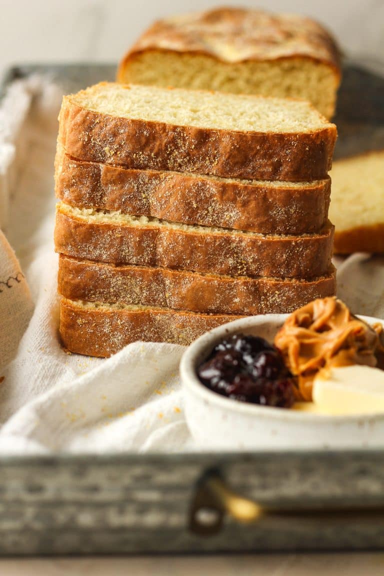 Side view of stacked English muffin bread on a gray tray.