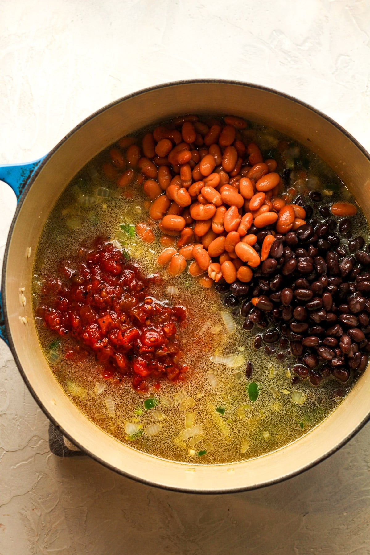 A stock pot of the rice after adding the liquids and beans.