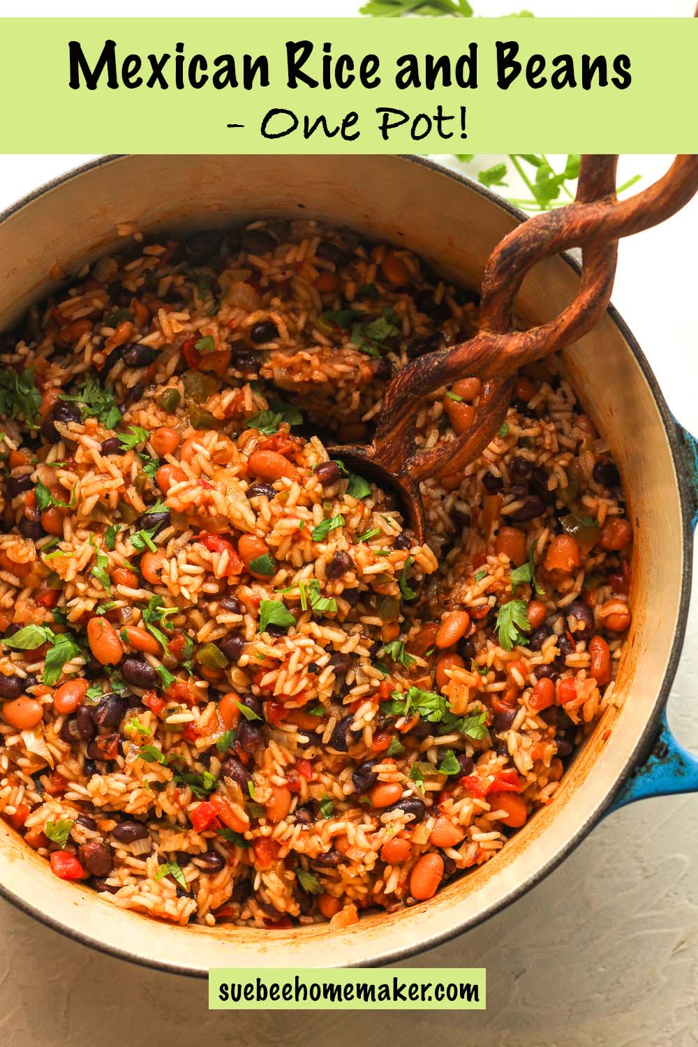 A large pot of Mexican rice and beans with a wooden spoon.