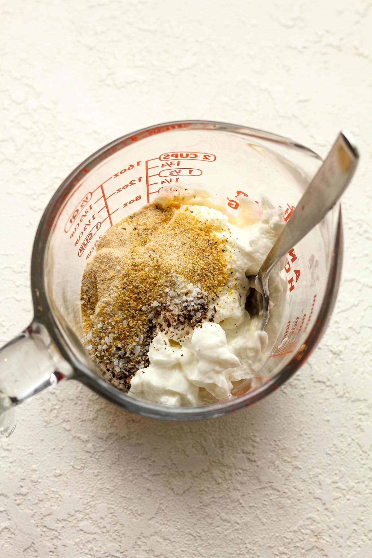 A measuring cup of the dressing ingredients before combining.