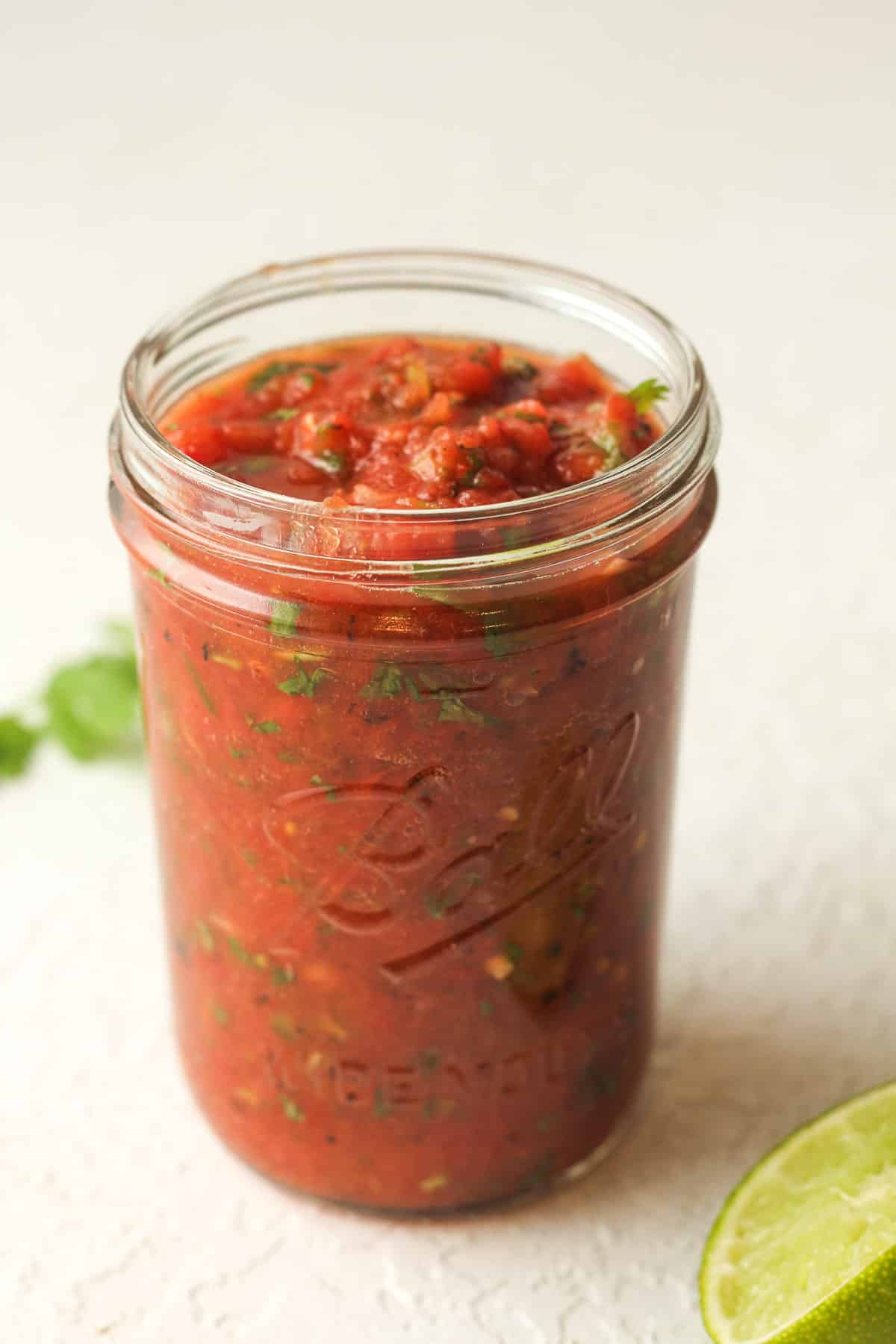 Side view of a 2-cup mason jar filled with blender salsa.