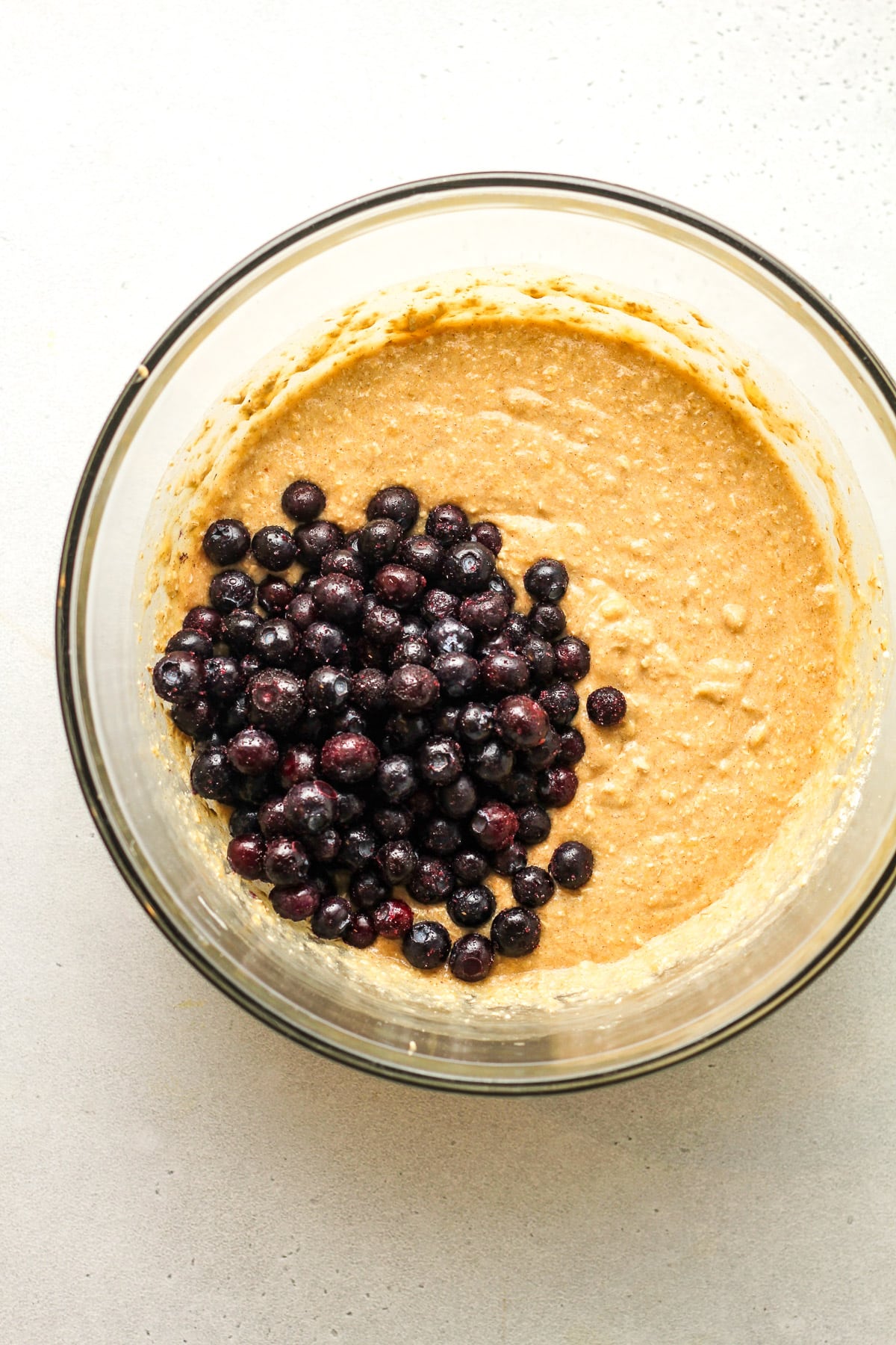 A large bowl of the batter and blueberries on top.