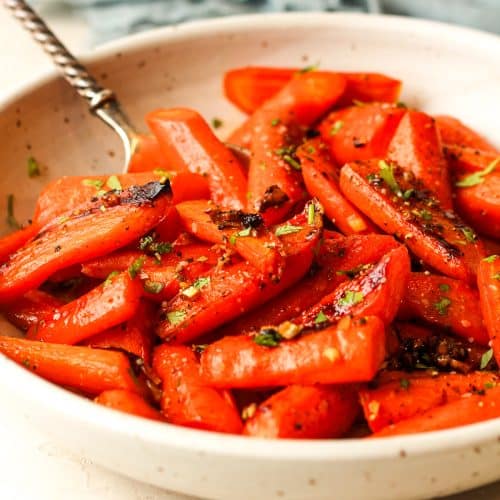 Side view of a bowl of brown sugar honey roasted carrots.