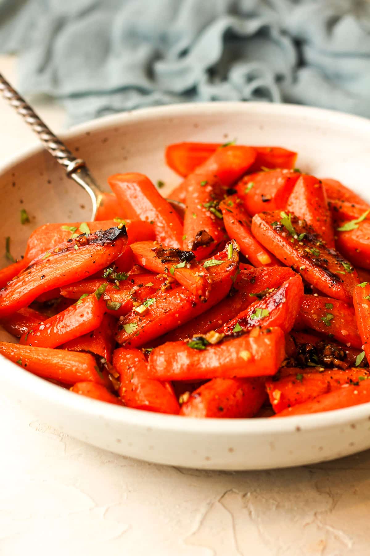 Side view of a bowl of brown sugar honey roasted carrots.