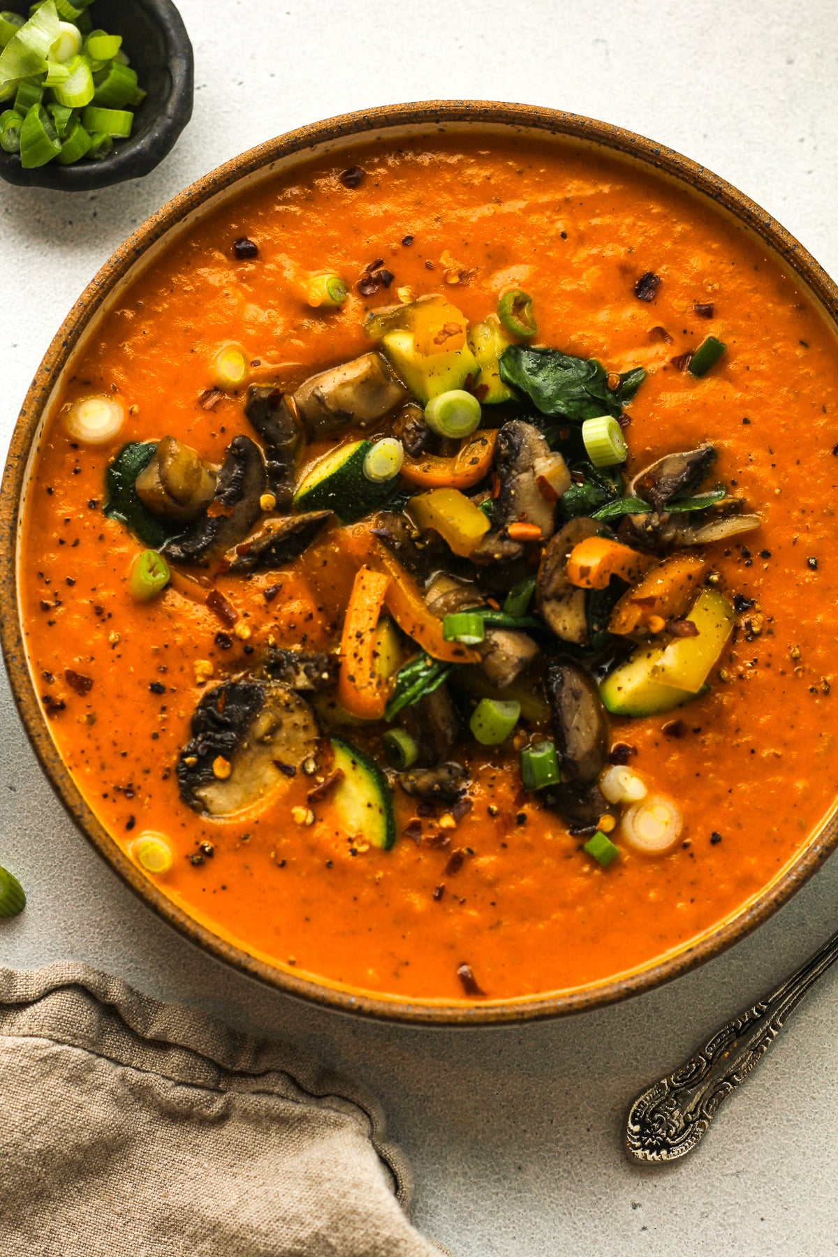 A bowl of coconut curry soup with veggies.