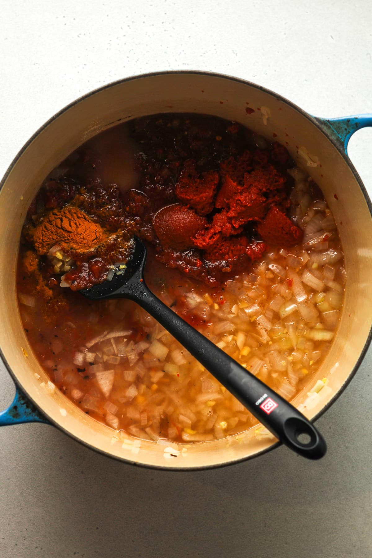 A pot of the sautéed veggies plus canned products and seasonings.