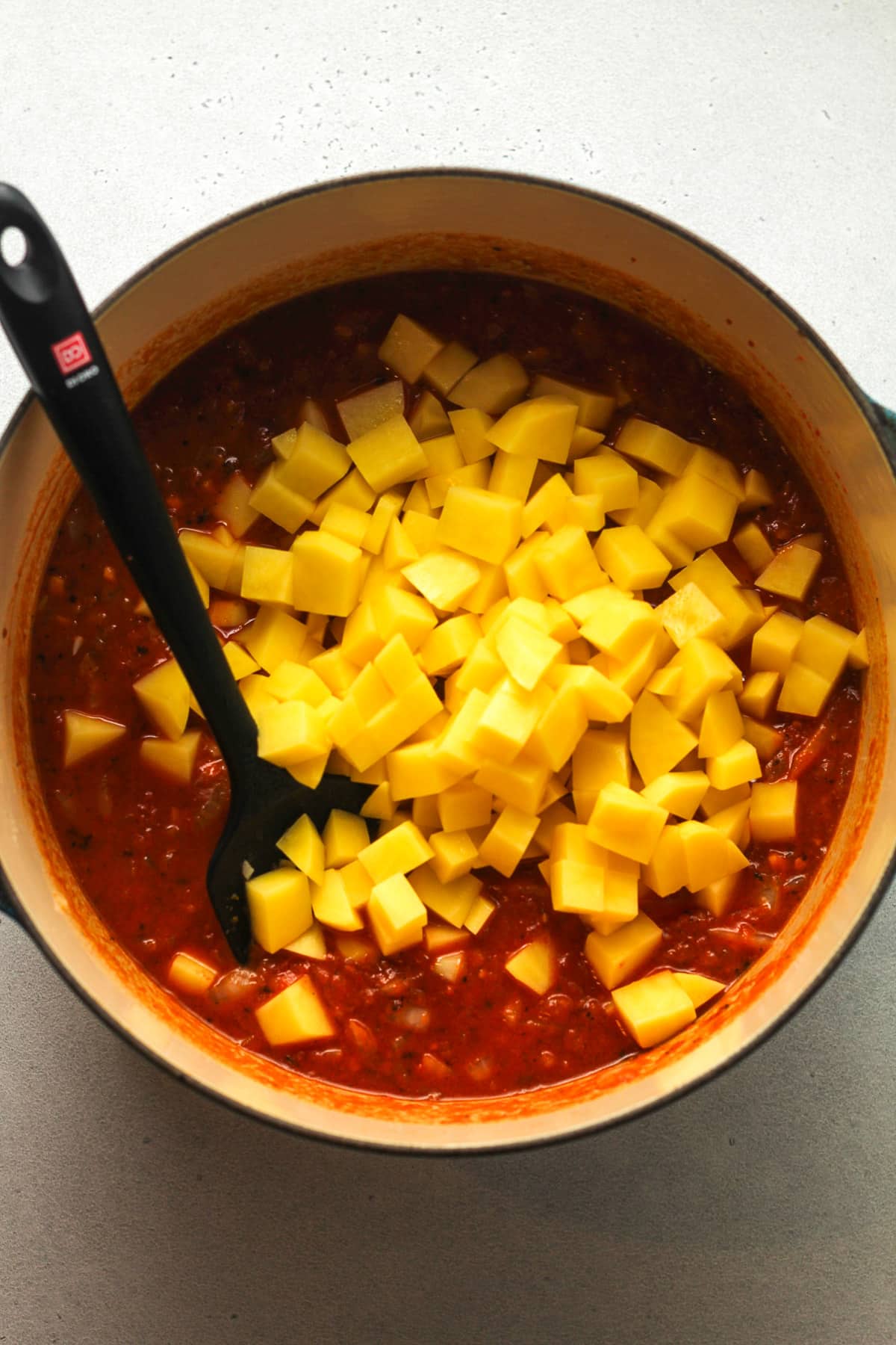 A pot of the soup after adding diced yellow potatoes.