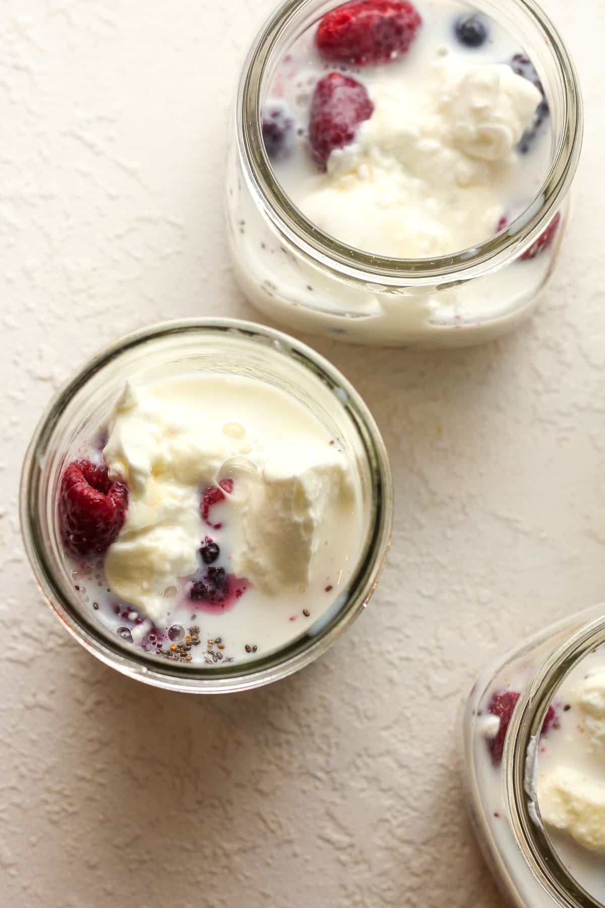 Overhead shot of jars of oats after adding milk.