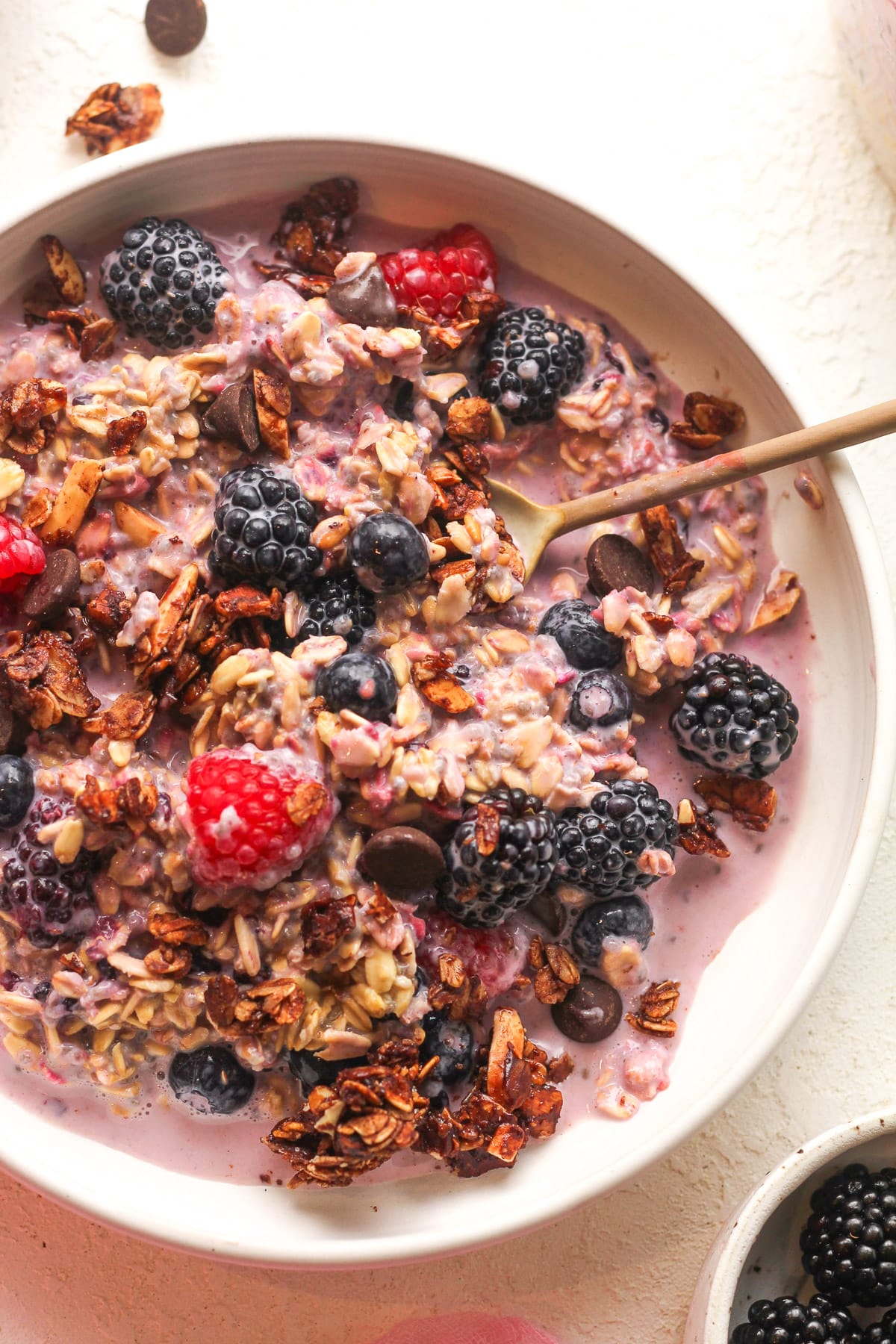 Closeup on a bowl of berry overnight oats with granola.