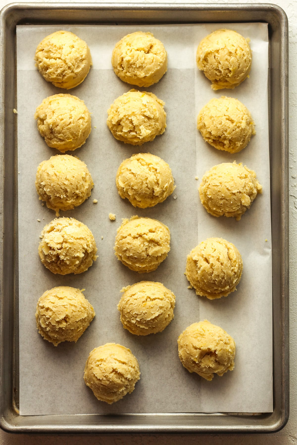 A tray of the lemon sugar cookie dough balls before baking.