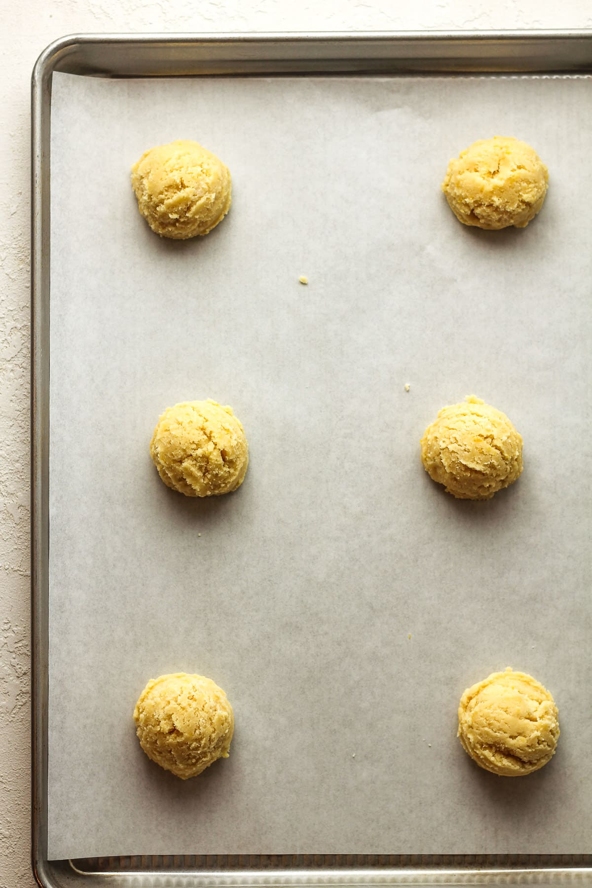 A baking sheet with the cookie dough rounds.