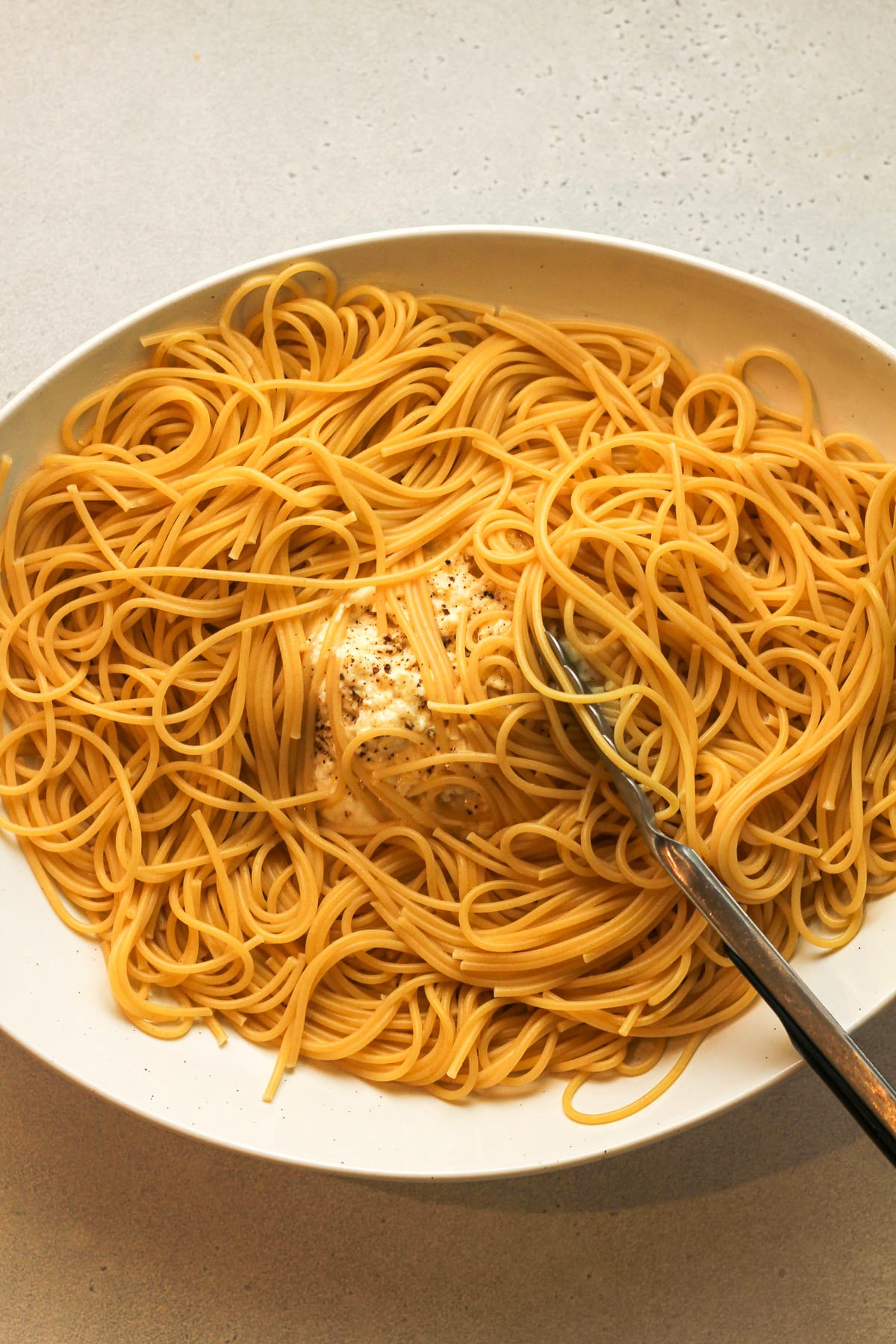 A platter of the ricotta mixture with the spaghetti noodles on top.