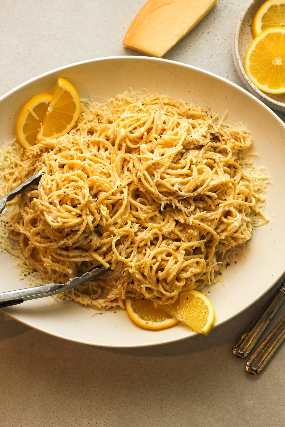 A platter of lemon pasta with lemon slices.