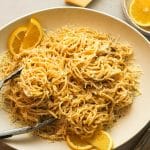 A platter of lemon ricotta pasta with a tongs.