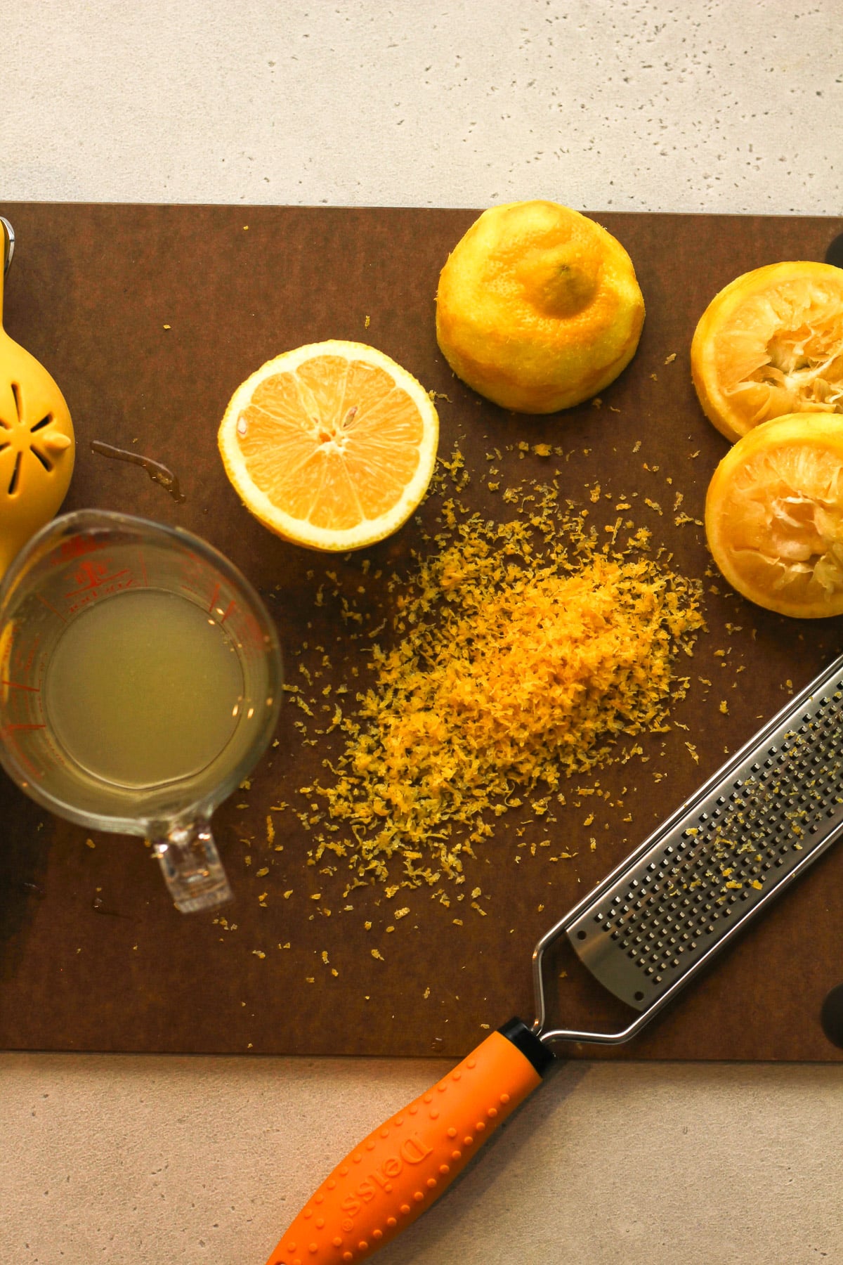 A board with the zested and juiced lemons.