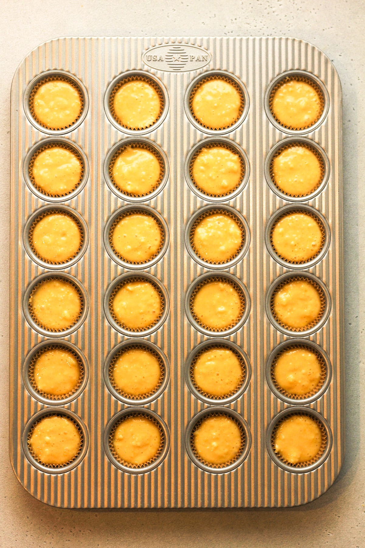 A mini muffin tin filled with batter.