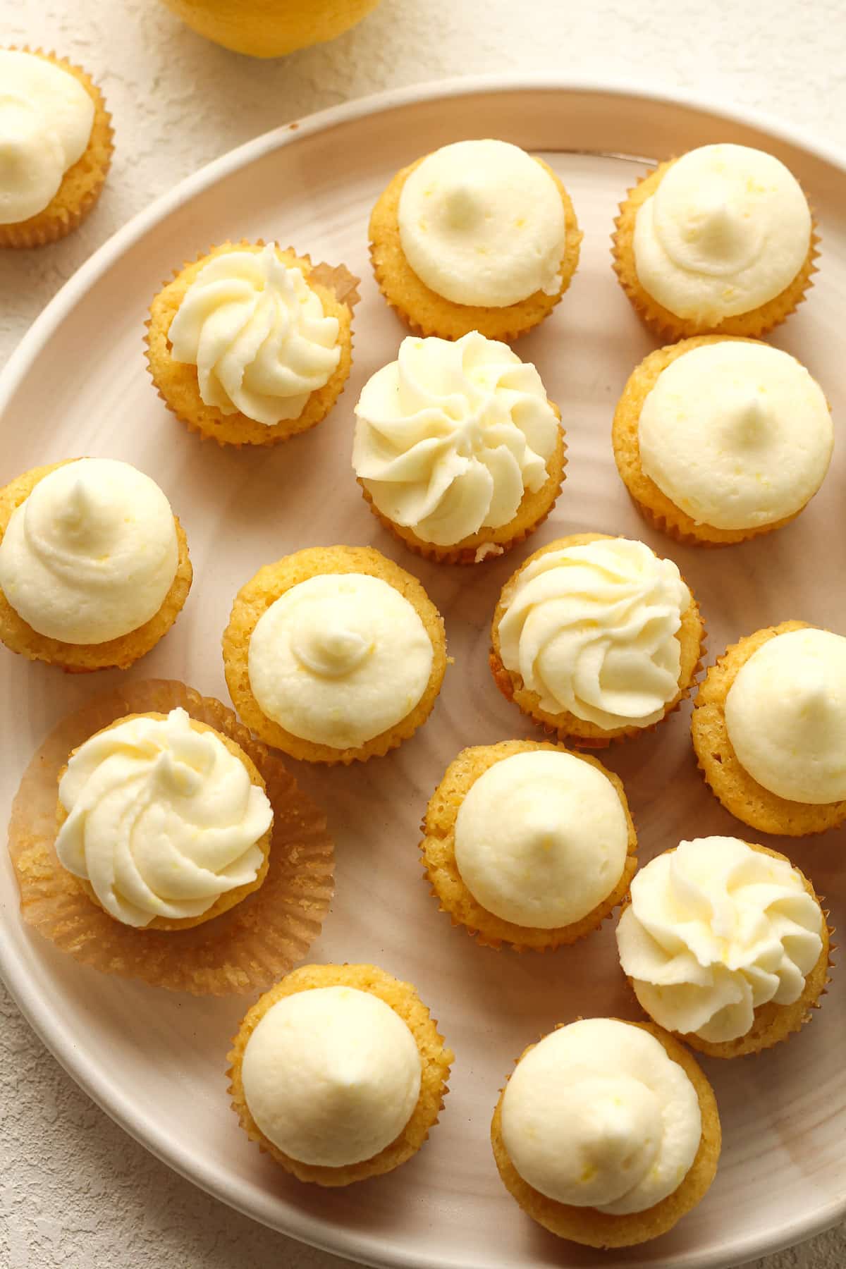 Overhead plate of lemon cupcakes with frosting.