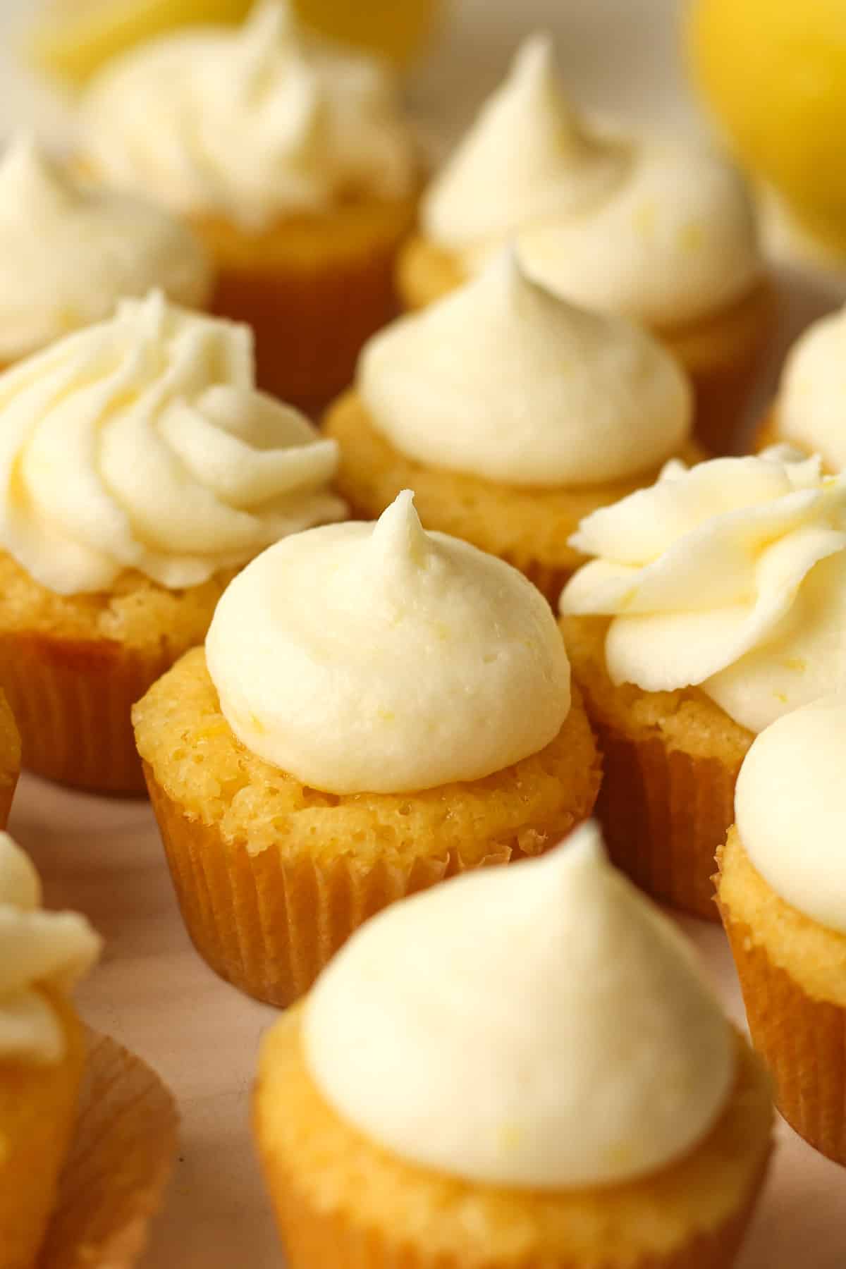 Side view of a plate of mini lemon cupcakes with lemon buttercream.