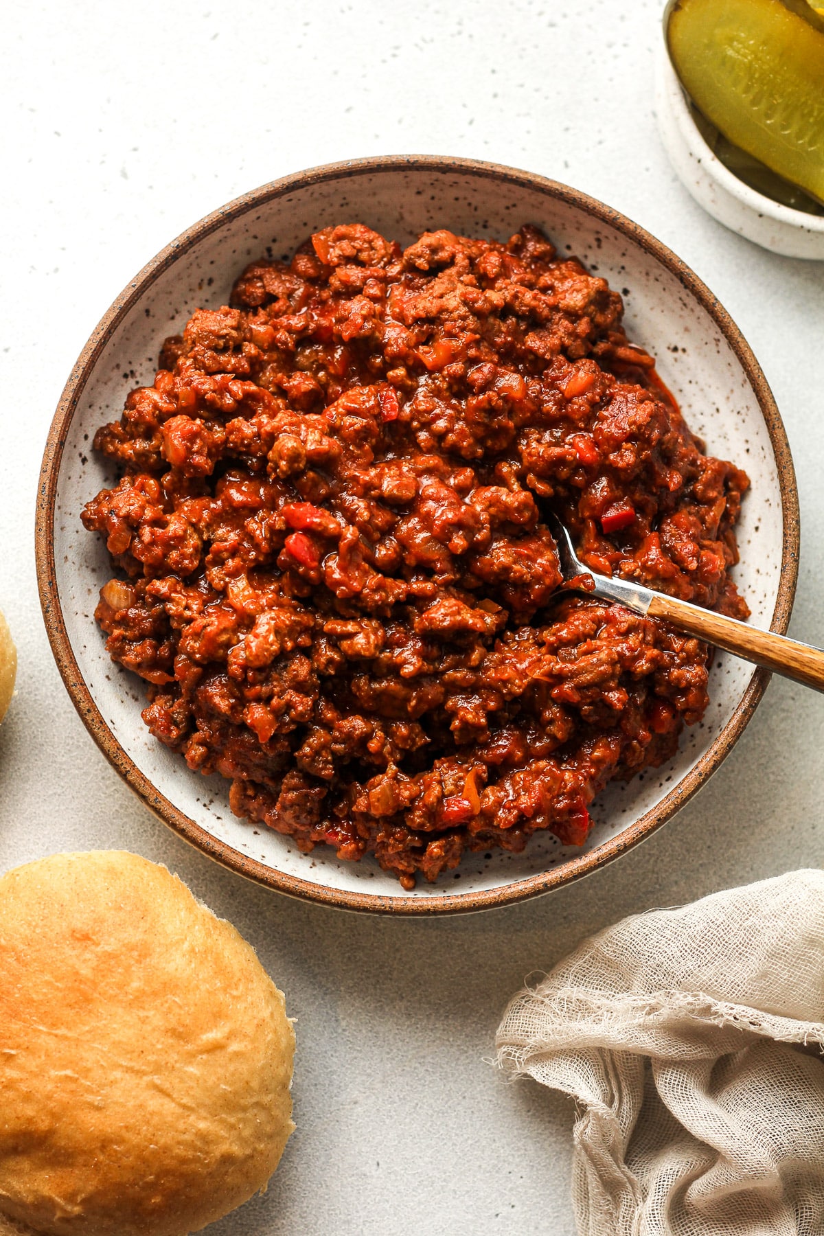 A plate of spicy sloppy joes with a spoon.