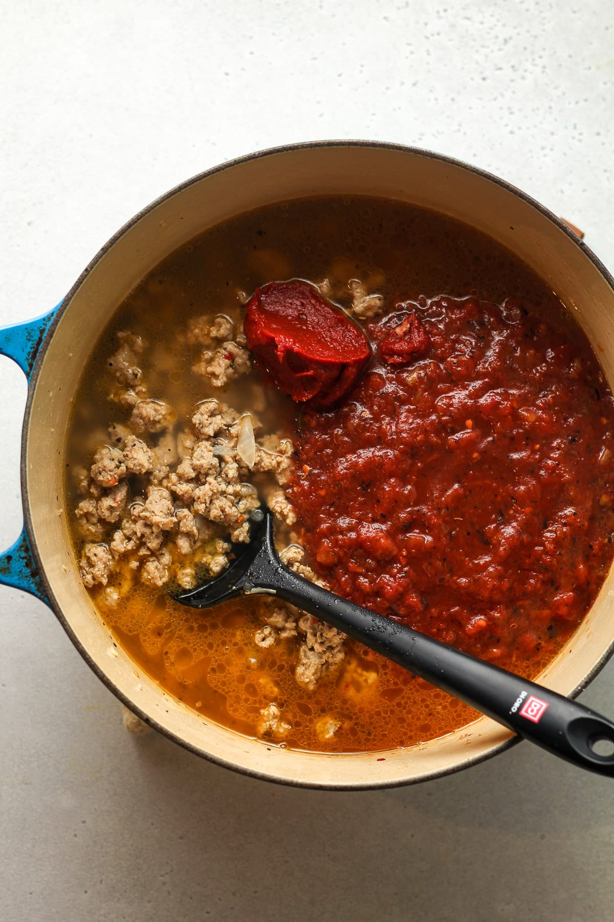 A pot of the soup base after adding in the tomatoes.