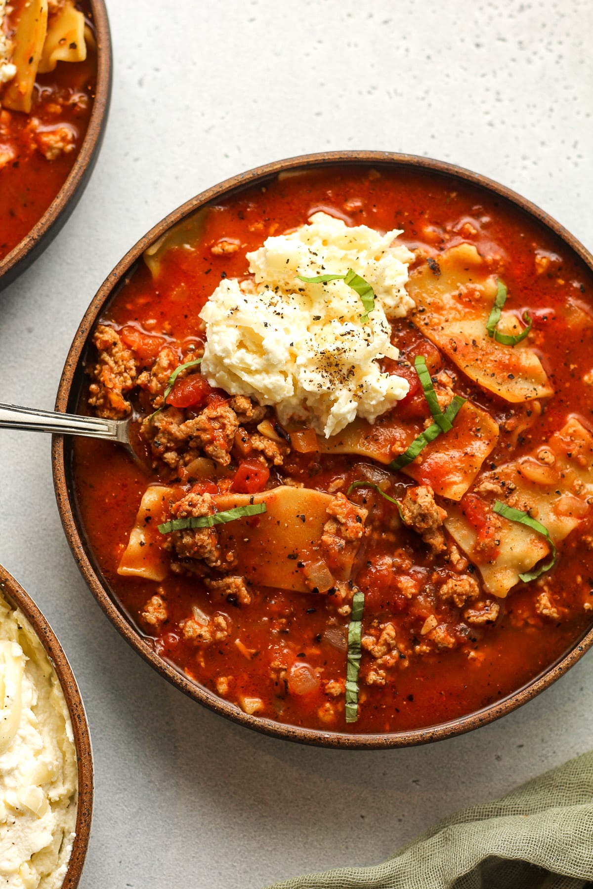 Two bowls of lasagna soup with ground turkey.