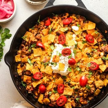 A large skillet of turkey tacos with toppings.