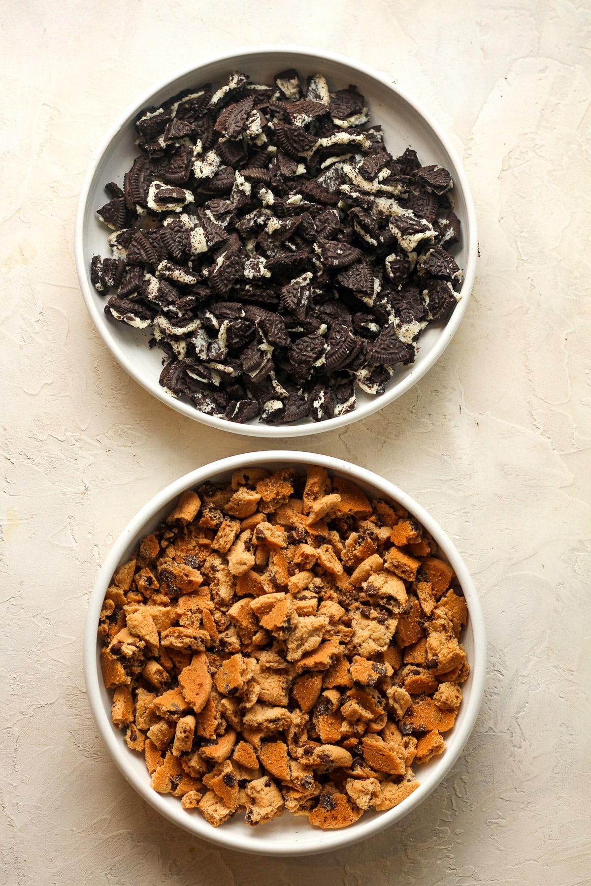 Two bowls - one with the crumbled Oreo cookies and the other with crumbled Oreo cookies.