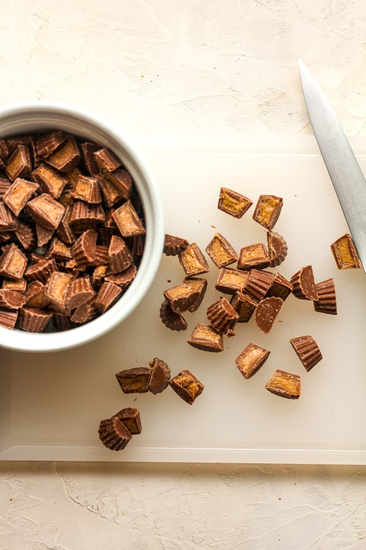 A cutting board with halved mini Reeses cups.