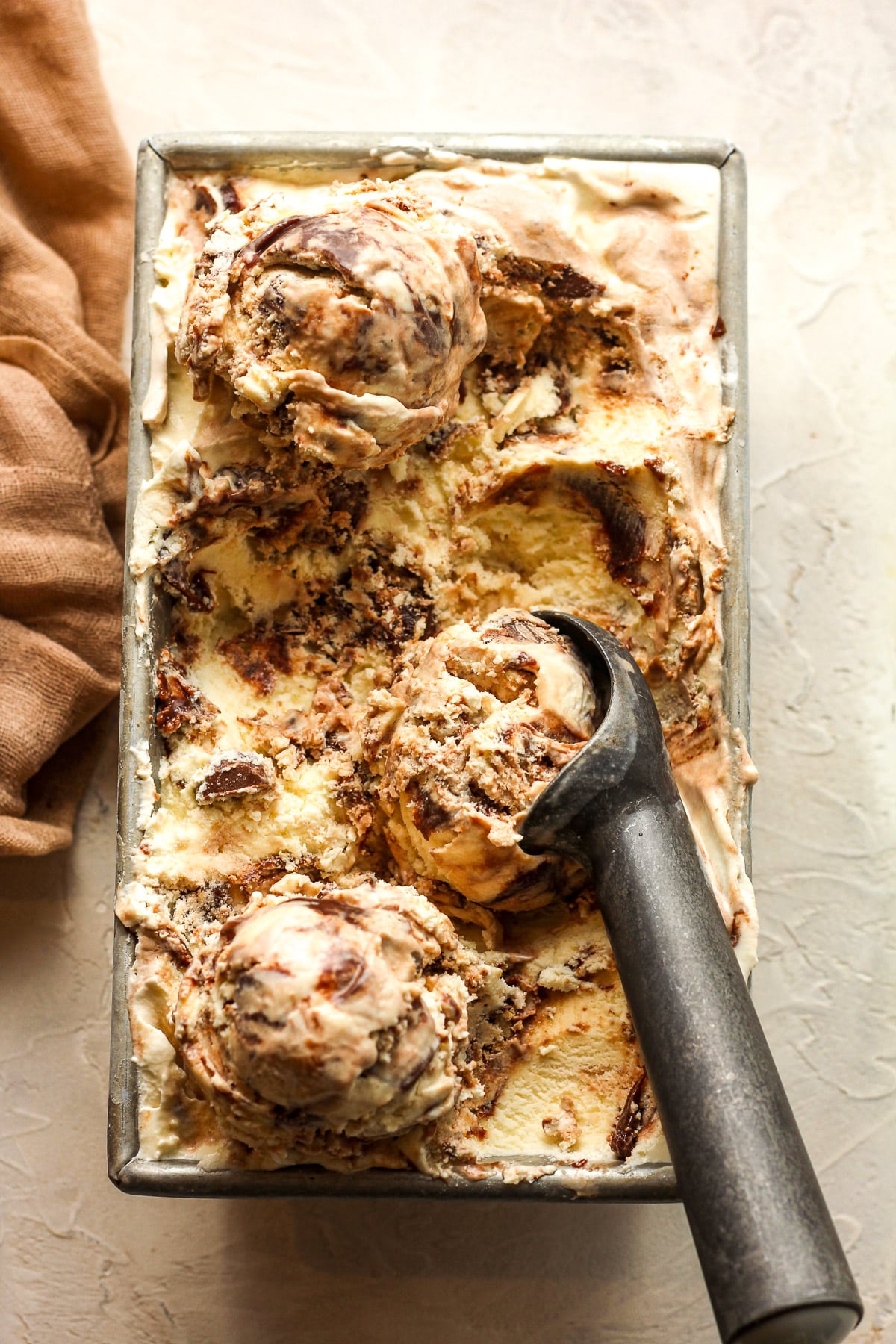 A pan of moose tracks ice cream with an ice cream scoop.