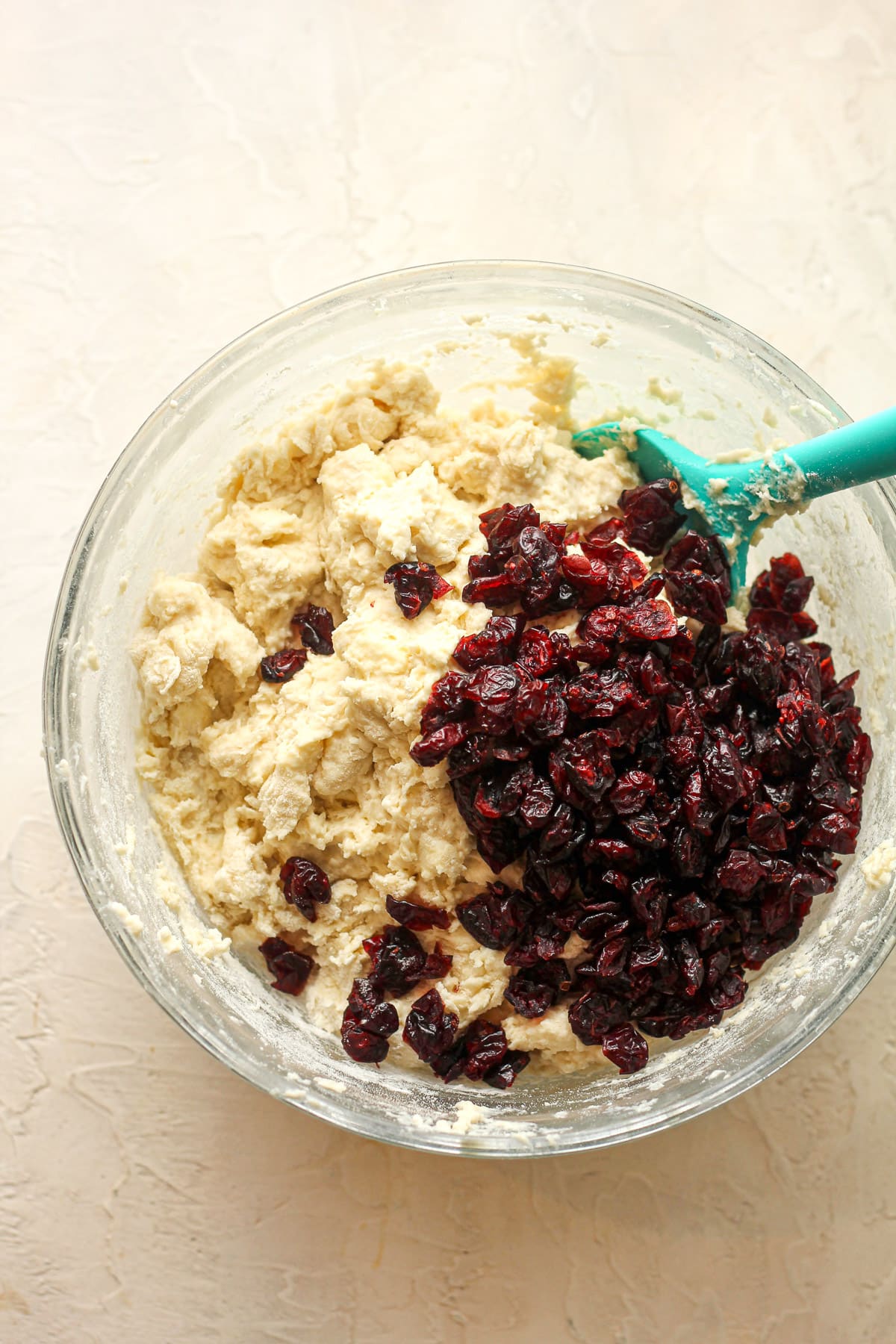 A bowl with the soda bread ingredients after adding dried cranberries.