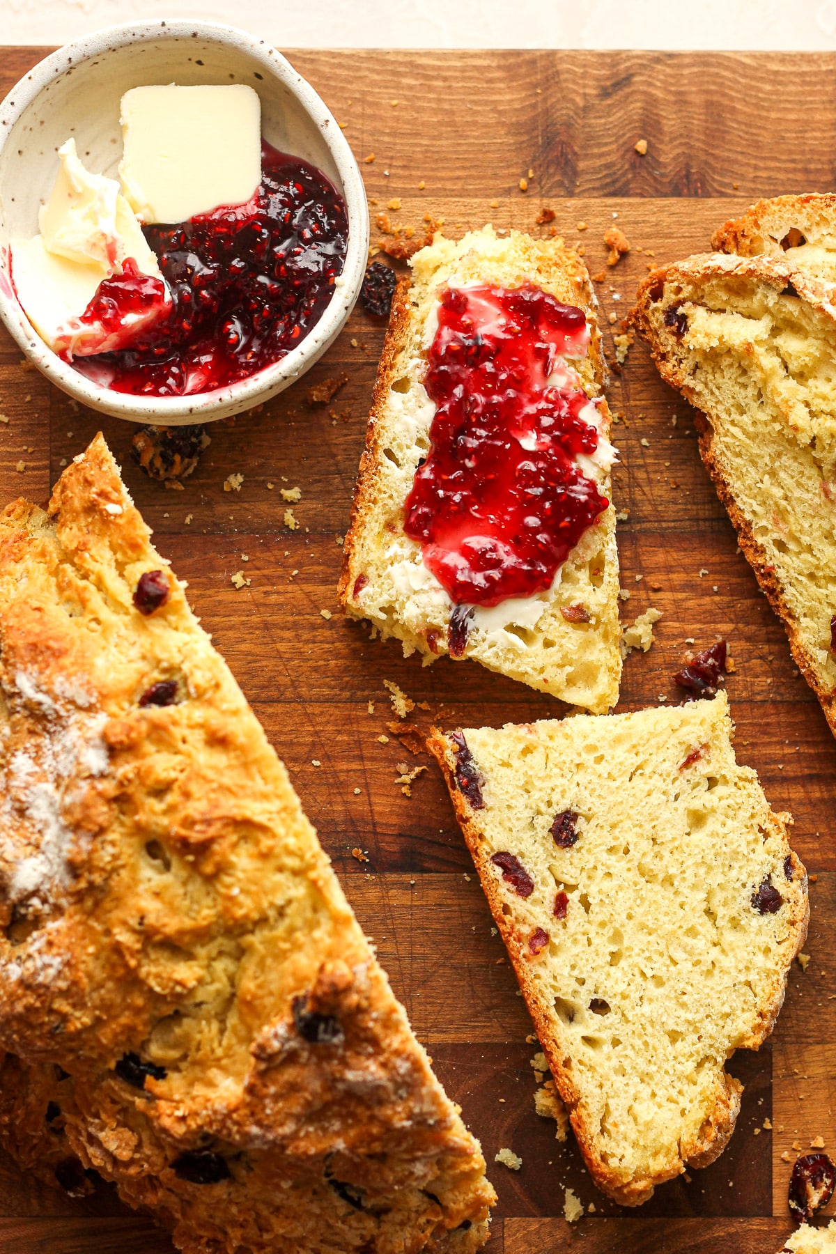 A half piece of Irish soda bread with butter and jelly with the remaining bread.