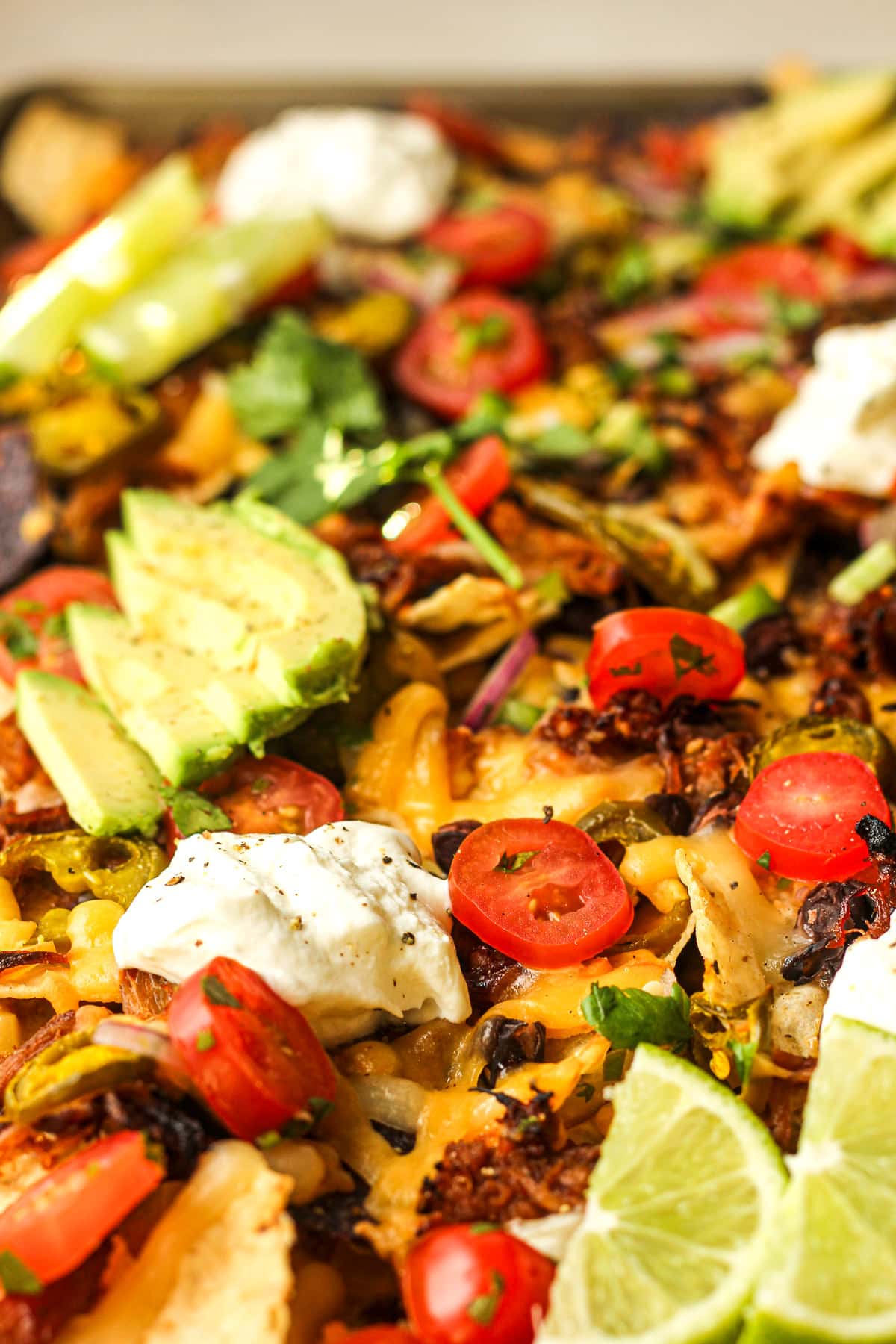 Side view of pulled pork nachos with melty cheese on top.